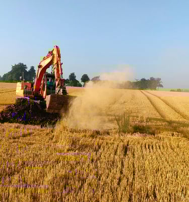 un pelleteur en plein décapage dans un champ pour trouver un puit de marnière