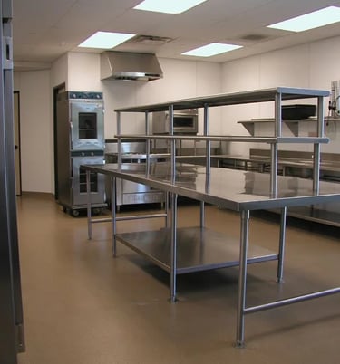 Commercial kitchen setup with tiered stainless steel prep benches and industrial equipment, from the About SSB team.