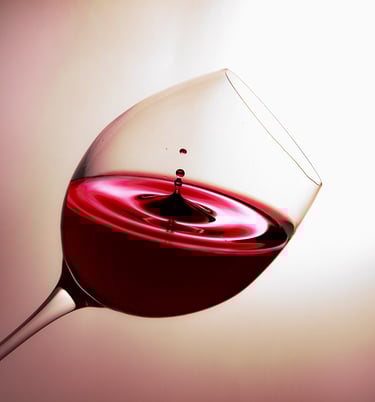 una copa de vino con unas gota cayendo en la copa