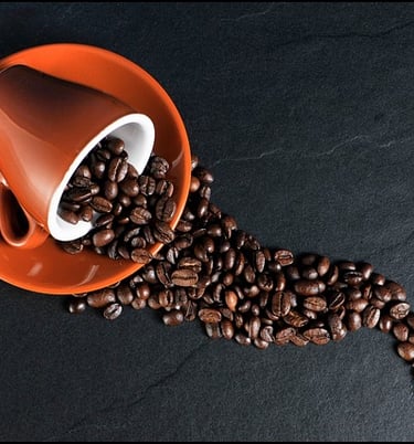 Una taza de granos de café se derramó de una taza de café