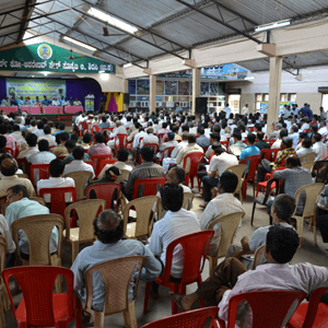 a large group of people sitting in chairs in a room