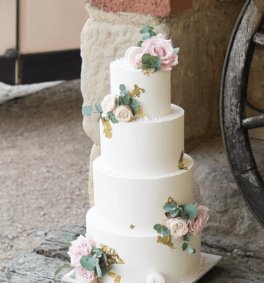 a wedding cake with a white and pink flowered cake