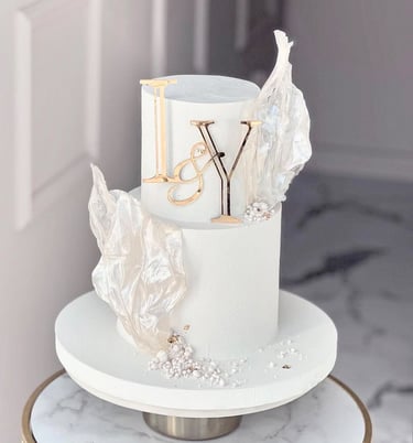 a white cake with a gold and silver cake topperf