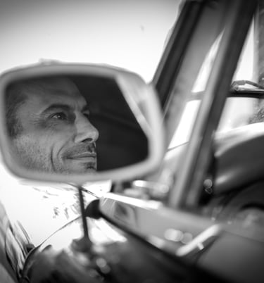 a man in a car mirror and a car mirror