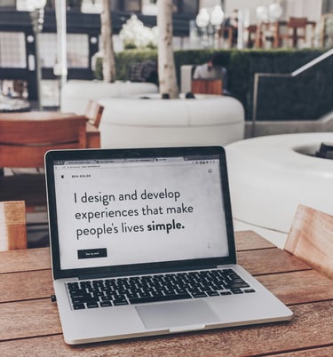 szürke Laptop egy fa asztalon felnyitva