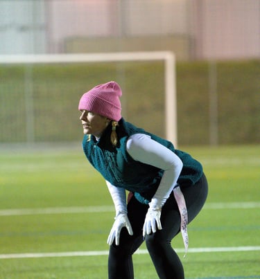 Flag Football Defensivspielerin Luca Alex von Limmat Lightning in Backpedal-Position im Training.