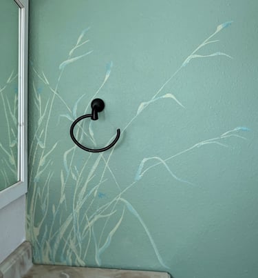 Small bathroom wall accent painting of tall bending dune grasses using cream colors, blues, and greens.