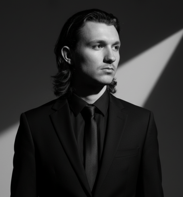 a man in a suit and tie with a light shining through the lens