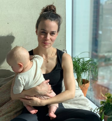 a Doula sitting, holding a baby