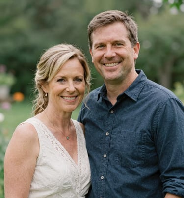 A warm and inviting portrait of the married photography couple smiling at the camera in a North American / US garden, genuine and heartfelt, Sage Green background.