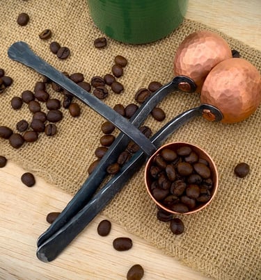 a pair of spoon and coffee beans on a table