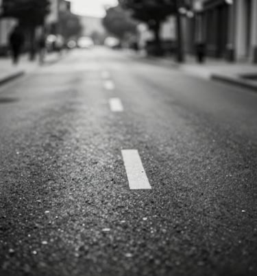 A high-contrast black and white landscape of an empty street, deep #0F0F0F blacks and crisp #F5F5F5 whites, cinematic atmosphere, lonely and artistic.