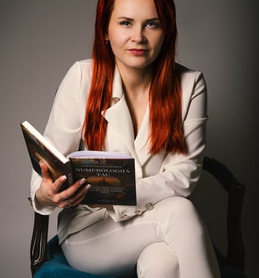 Numerologės Jolantos profesionalus portretas su knyga „Numerologija Tau“, simbolizuojantis jos ekspertines konsultacijas, ska