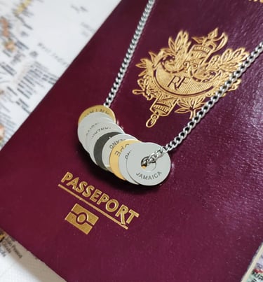 Silver necklace with engraved country tokens resting on a burgundy French passport and world map.