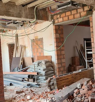 Travaux de démolition intérieure avec ouverture de mur porteur et évacuation des gravats en cours.