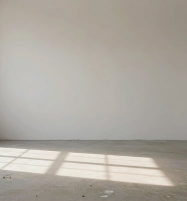 Atmospheric shot of an empty studio, sunlight hitting a floor splattered with #6B705C paint, #F9F8F7 walls, peaceful sanctuary vibe.