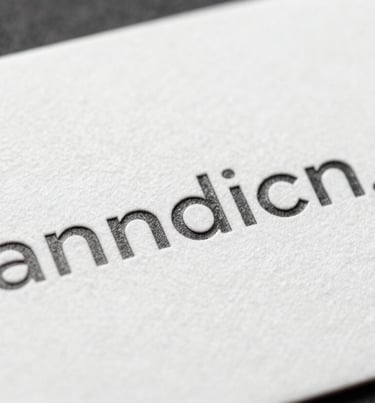 Close-up of a high-quality textured business card with minimalist charcoal typography on a white surface.