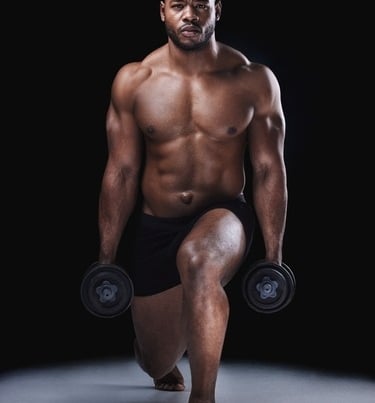 A muscular shirtless man performing weighted lunges with dumbbells during a fitness workout.