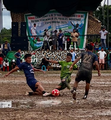 Athletes competing in a muddy indigenous community soccer match at the Copa Indigena tournament.
