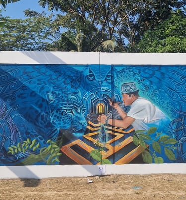 Indigenous street art mural featuring a shaman, a jaguar, and an owl in vibrant blue tones.