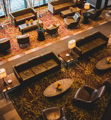 Luxury hotel lobby lounge with leather sofas, designer armchairs, and warm ambient lighting.