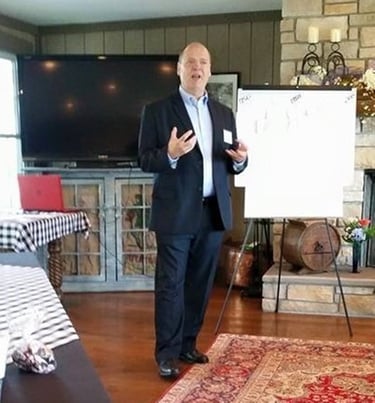 a man in a suit and tie standing in front of a white board