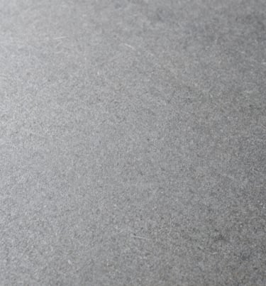 A close-up photographic texture of a smooth grey stone surface, soft natural lighting, minimalistic and clean, International / Western.