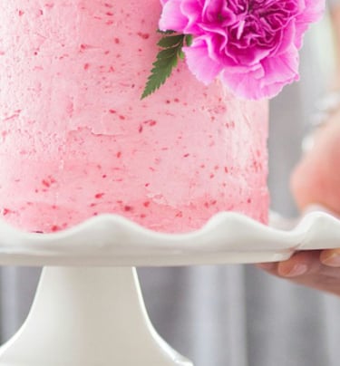 a woman holding a cake with candles and flowers.Tourism Consulting in England, Spain, Hungary