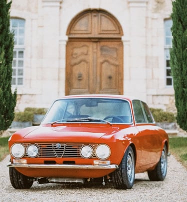 An image of a red 1974 Alfa Romeo lined by two rows of trees