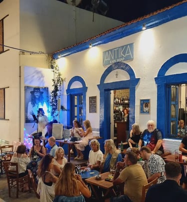 a group of people sitting at tables outside