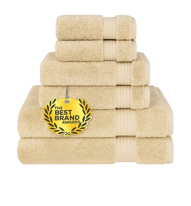 Stack of six plush white cotton towels, folded.