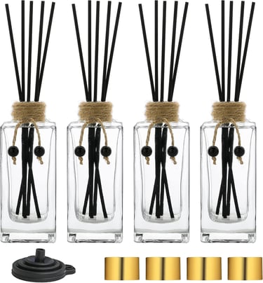 a group of four glass vases with sticks and sticks