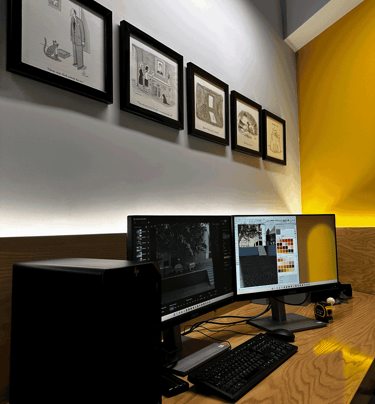 Área de trabajo con iluminación indirecta, doble monitor y muro amarillo decorado | KARÄNA