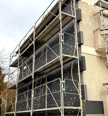 chantier en cours façade de maison avec pose de plaques isolantes et chevilles