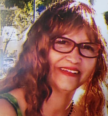 Woman with glasses smiling.