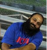 Man with blue shirt and beard smiling