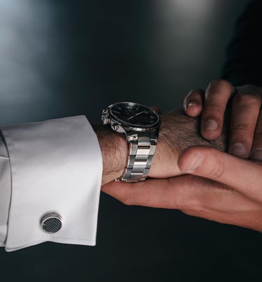 a man in a suit and tie is holding a watch