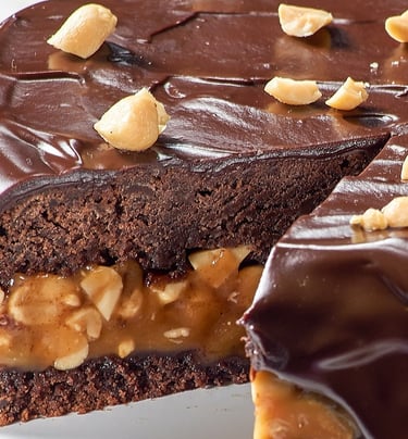 كعكة مغطاة بكريمة الشوكولاتة والمكسرات في الأعلى