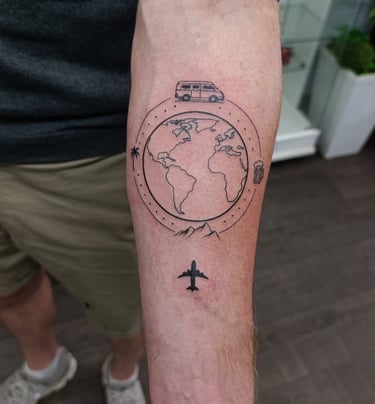 Man's arm tattoo of a plane flying over a globe.  Tattooed at Katarsis Studio in Lima