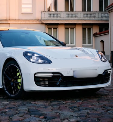 an Enlab white porsche panamera parked in front of a building