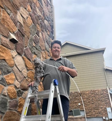 After a King Organic Dryer vent cleaning man standing on ladder holds large pile of lint