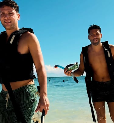 two men standing in the water with a parrot on their back