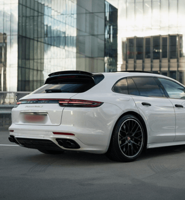 an Enlab white porsche panamera parked in front of a building