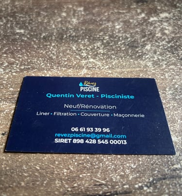 Verso d'une carte de visite bleu foncée avec logo créée par OpéPro pour Rêvez Piscine