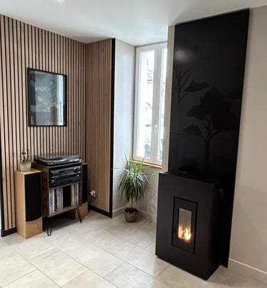 Poêle à granulés noir design avec flamme visible, intégré dans un salon moderne avec mur en tasseaux