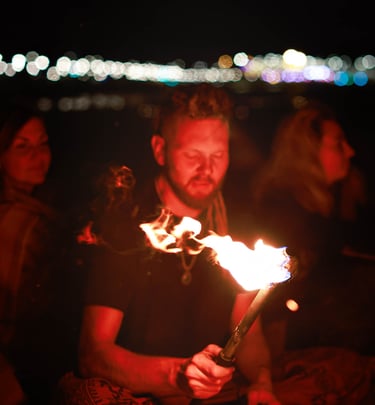 A man holds a torch while others listen his story. Photo by Martin Vähk