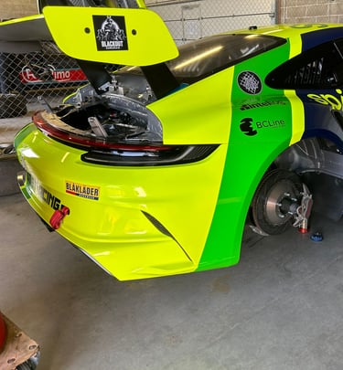 an Enlab yellow and green Porsche car with a yellow and black car in the background
