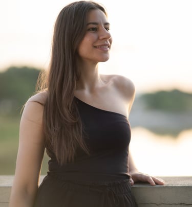 a woman in a black dress standing on a ledge