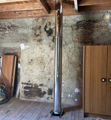 Conduit de fumée inox installé dans une maison ancienne lors d’un chantier de rénovation