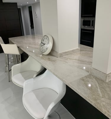 a clock on a counter top with three chairs